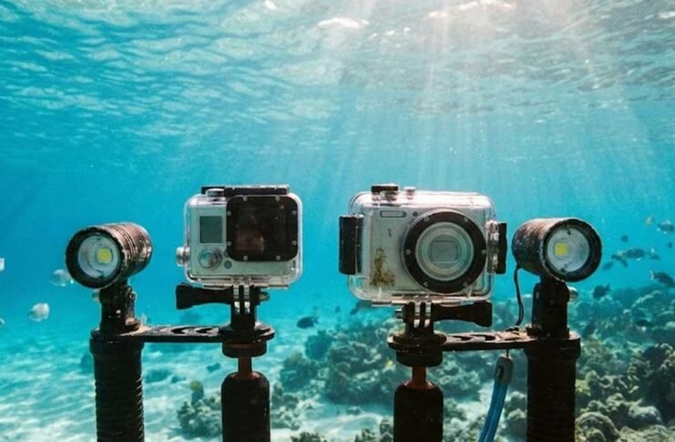 Action camera and compact camera used underwater, showing differences in size, controls, and shooting style