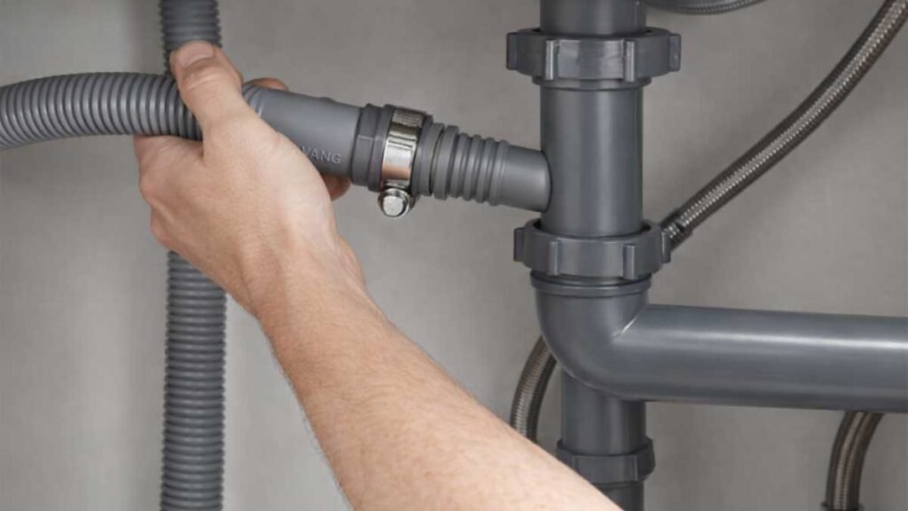 Connecting dishwasher drain hose to gray sink trap under kitchen sink